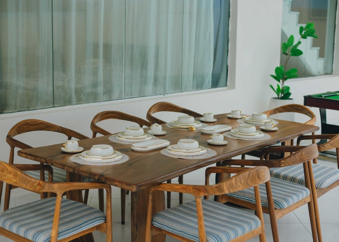 A long wooden dining table laid for ten
